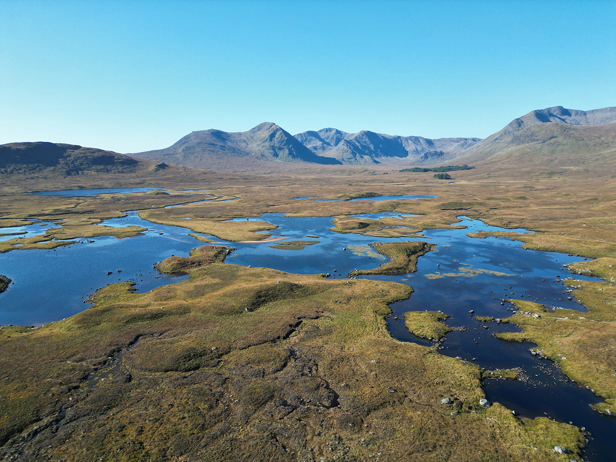 Open water, rock and distant mountains across Rannoch Moor